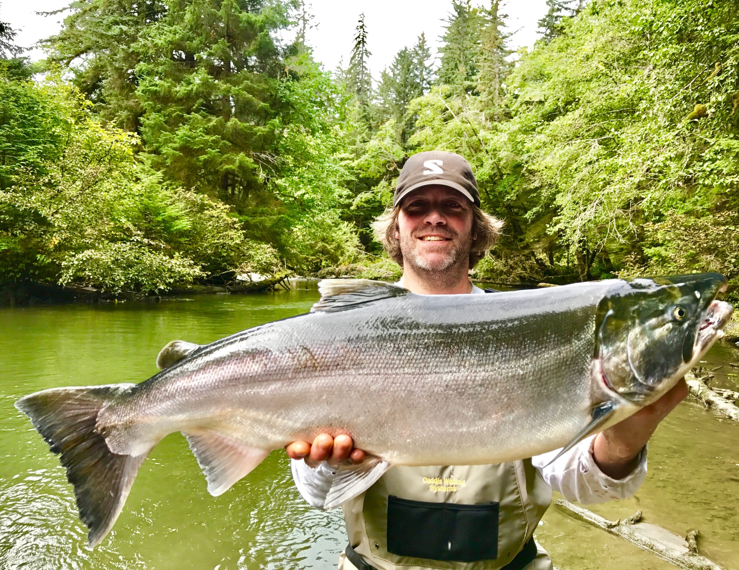 Children holding caught salmon on Alaska river
